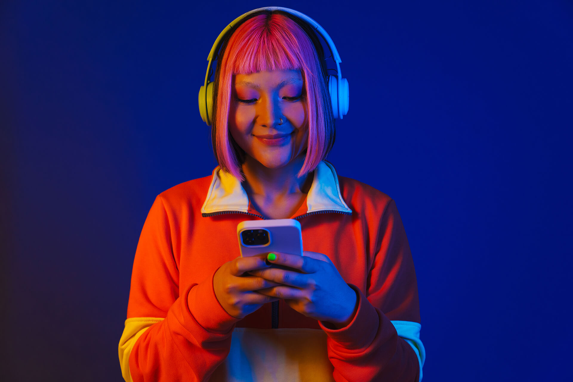 asian-girl-in-headphones-smiling-and-using-mobile-2022-12-01-22-52-14-utc